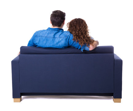 Back View Of Young Couple Sitting On Sofa Isolated On White