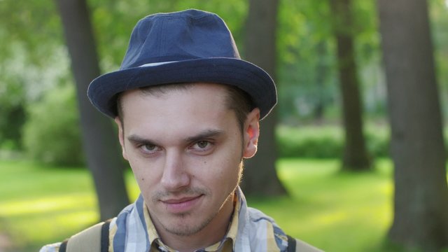 Portrait of boy in hat showing shyness, timid. Outdoor. Summer