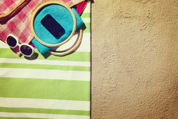 Top view of sandy beach with summer accessories and copy space
