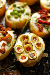Crostini with addition of melted mozzarella cheese and green olives