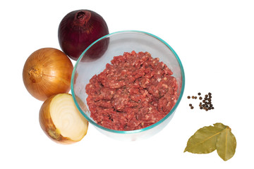 Beef mince in transparent bowl with onions, black pepper and bay leafs  isolated on white