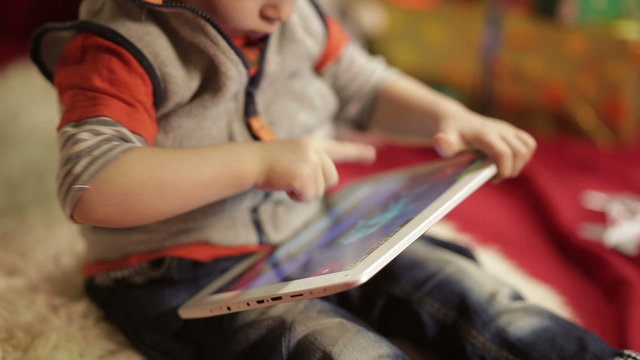 Boy with tablet PC near christmas tree