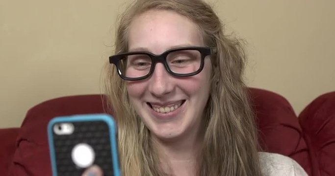 Girl laughing while having a face to face conversation on her cell phone using the video capability.