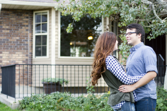 couple outside of new home celebrating new purchase