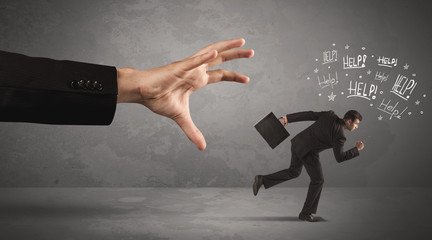 Business person running away from big hand