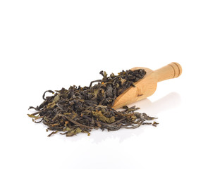 Wooden spoon over dry green tea leaves