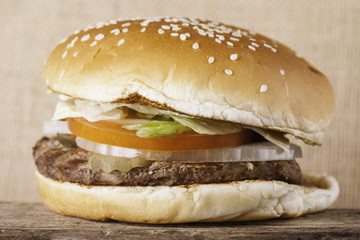 Burger closeup on an old wooden board vintage background