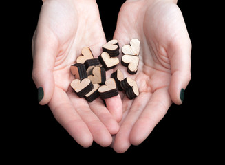 Female hands holding wooden hearts