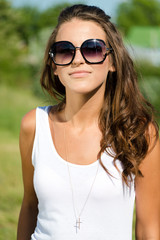 Beautiful sexy woman on the nature background in sunglasses