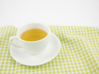 The cup of Japanese green tea on green cotton fabric.