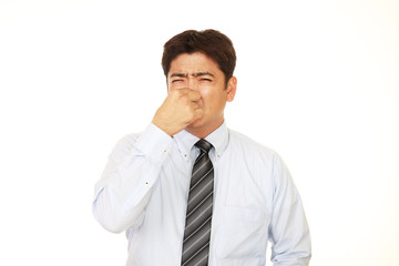 鼻をつまむ男性