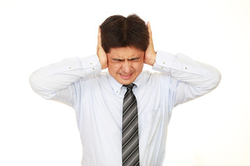 耳を抑える男性