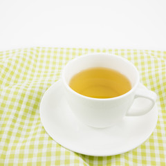 The cup of Japanese green tea on green cotton fabric.