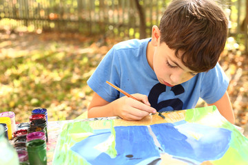 preteen handsome boy painting with gouache