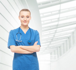 Beautiful and cheerful intern with stethoscope and blue coat in