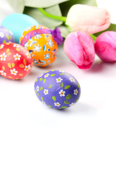 Easter eggs and flowers on white