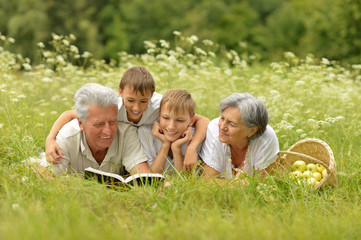 Family with book on summer grass