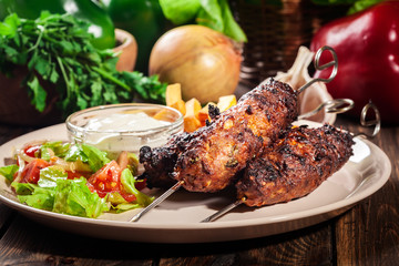 Grilled shish kebab served with fried chips and salad