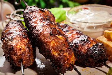 Grilled shish kebab served with fried chips and salad