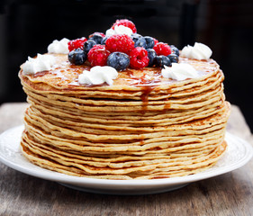 Fresh golden pancakes with raspberries, blueberries