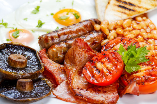 Full English breakfast with bacon, sausage, egg, beans and mushrooms