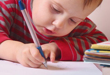 Little beautiful girl writing in her book
