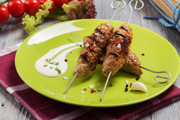 Barbecued kofta - kebeb with vegetables on a plate.
