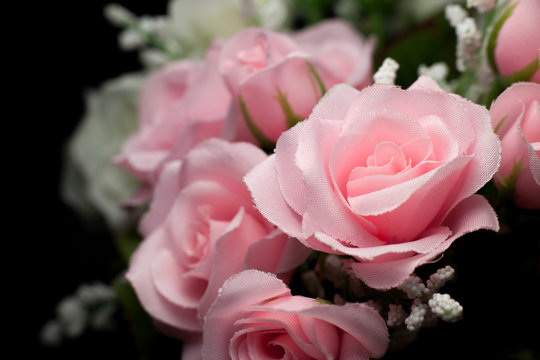 artificial pink rose on black background