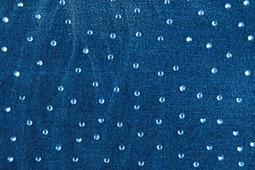 Abstract background with blue rhinestones on denim