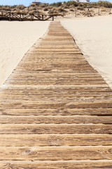 Wooden road on sandy beach