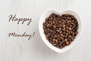 Happy Monday note and coffee bean in a bowl in the form of heart