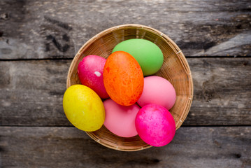 Easter eggs in the basket on rustic wooden background