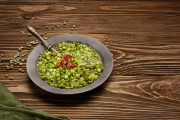 Green lentil soup with dried tomato and a spoon and  a napkin