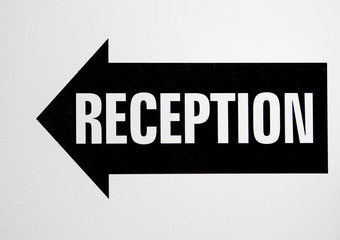 Hotel reception signage in balck and white. Reception is in an arrow