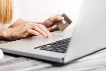 Female hands holding credit card and using laptop. Online shopping concept