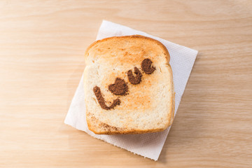 Love message on Bread sliced on wooden background.