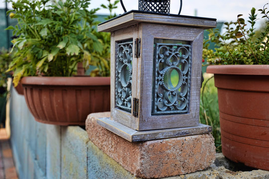 lantern on bricks wall at summertime, Garden lamp with two flowerpots,  vintage kerosene  lamp isolated on garden background,