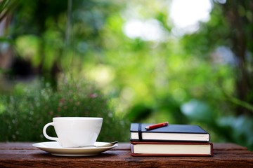 Notebook with pencil and cup on wooden table