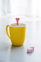 Hot chocolate drink in yellow cup and heart shape marshmellows o