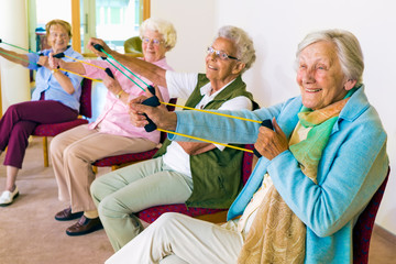 Cheerful senior women exercising their arms. - obrazy, fototapety, plakaty