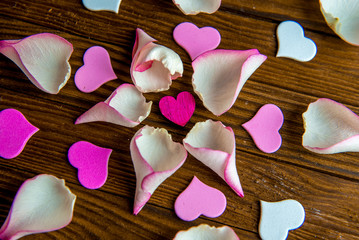 Rose petals leaves on a brown wooden background, top view.
