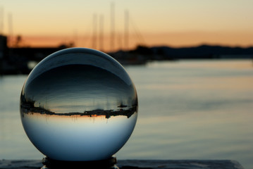 Crystal ball images with boats and sunset in background