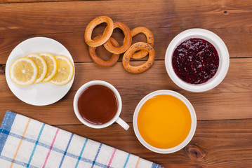 Cup of tea with cakes on a wooden table.
