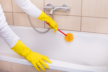 Woman cleaning bathtub