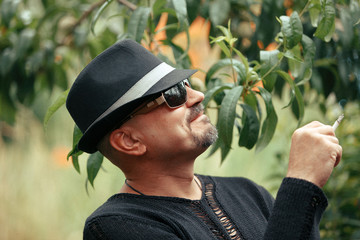 man with hat smoking at garden