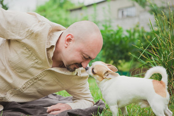 man playing with small dog