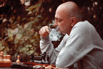 man smoking a pipe playing chess