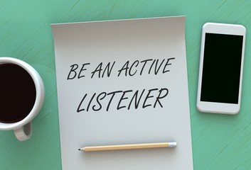 Be An Active Listener, message on paper, smart phone and coffee on table