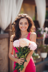Beautiful brunette with a bouquet of pink flowers