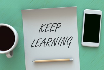 Keep Learning, message on paper, smart phone and coffee on table
